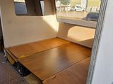 a bed in the back of a truck with a wooden floor