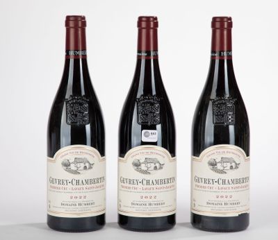 trois bouteilles de vin rouge sont alignées sur une surface blanche
