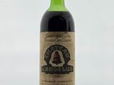 une bouteille de vin posée sur une table à côté d'un verre