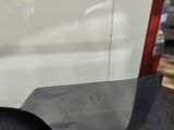 a white van parked in a parking lot with its door open