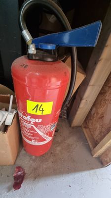 a fire extinguisor in the corner of a garage