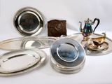 de nombreuses assiettes et plateaux en argent posés sur une table