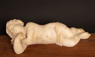 an image of a statue of a baby laying down on a table