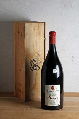 une bouteille de vin posée sur une table à côté d'une caisse en bois
