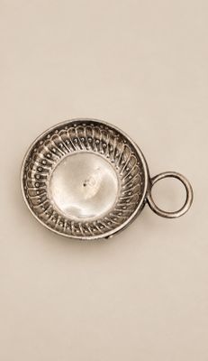 un vieux plat en argent surmonté d'un anneau