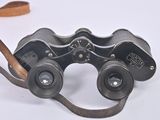 an old pair of binoculars sitting on top of a white surface