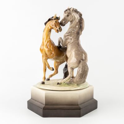 statue représentant deux chevaux en train de se battre, posée sur un socle