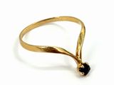 a close up of a gold ring with a black stone