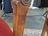 a red chair with a wooden arm rest on a carpet