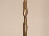 a gold sculpture of a woman standing on a glass table