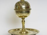 une assiette ancienne en laiton avec un couvercle et un socle, sur fond blanc