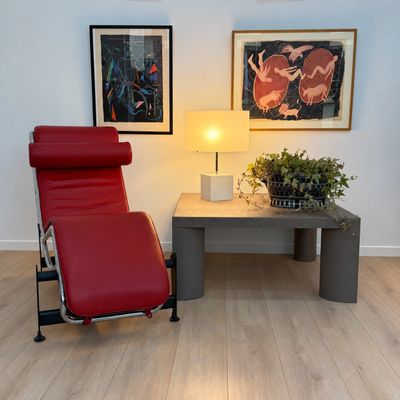 un fauteuil inclinable rouge posé devant une table basse