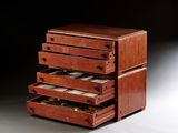 une petite boîte en bois surmontée de quatre tiroirs