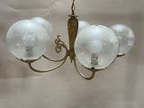 an image of a chandelier with three glass globes hanging from the ceiling