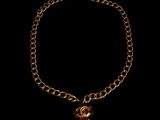 a close up of a gold chain bracelet with a heart charm