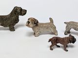 four small figurines of dogs on a white surface