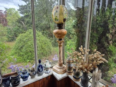 une lampe posée sur le rebord d'une fenêtre, à côté de celle-ci