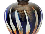 a glass vase with a black and orange design on it
