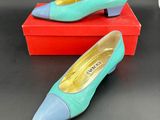 une paire de chaussures bleues et vertes posées sur une boîte rouge
