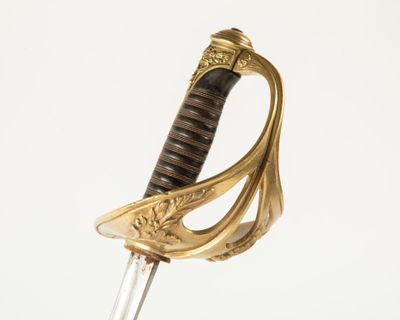 une image d'une épée avec un manche en or sur un fond blanc