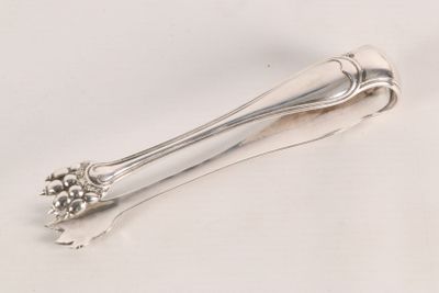 a silver spoon with a flower on it on a white surface