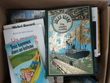 many books in a box that are sitting on a table