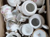 many cups and saucers in a cardboard box