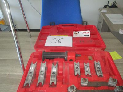 une mallette rouge contenant des outils, posée sur une table