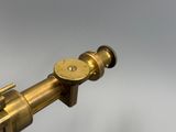 un gros plan d'un télescope en laiton sur fond blanc