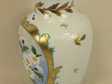a white vase with a gold rim sitting on a table
