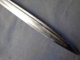 a silver sword that is laying on a blue cloth