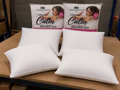 deux coussins blancs posés sur une table en bois dans un magasin