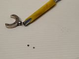 un gros plan d'une clé et d'un tournevis posés sur une feuille de papier