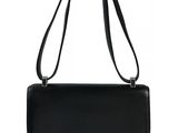 a black leather handbag with a metal handle