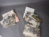 many old postcards on the table and a pair of scissors on the table