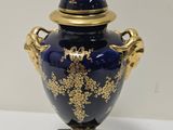 un vase bleu orné d'une décoration dorée