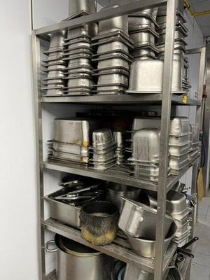 many pots and pans on the shelves in the kitchen