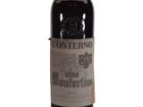 an old bottle of wine sitting on top of a white table