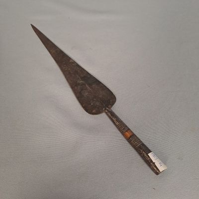 un vieux couteau avec un manche en bois sur une surface blanche