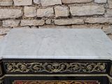 a marble top table with a black base and gold accents