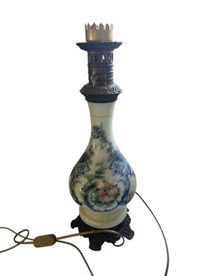 une lampe sur laquelle est posé un vase bleu et blanc