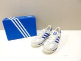 pair of white and blue adidas sneakers next to a blue box