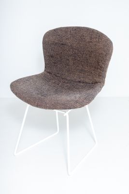 La chaise est en laine et possède une structure en métal blanc