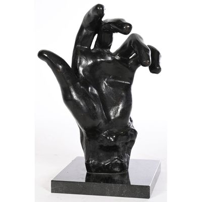 sculpture représentant une main tenant un oiseau, posée sur un socle en marbre noir