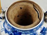 a blue and white vase with a bamboo stick sticking out of it