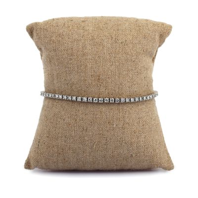 a close up of a pillow with a diamond bracelet on it