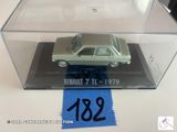 une petite voiture miniature dans une vitrine transparente posée sur une table