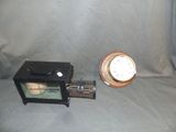 a small clock sitting next to a small clock on a table
