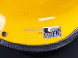 a close up of a yellow helmet with a sticker on it