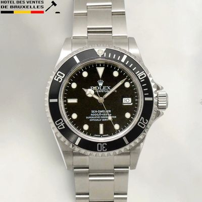 a rolex watch with a black dial on a silver bracelet
